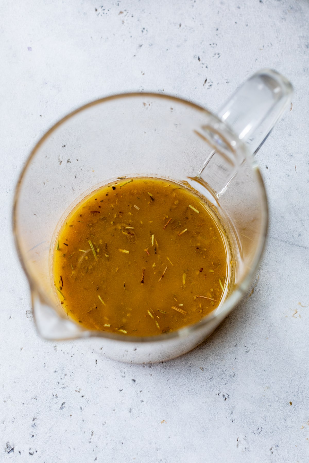 Italian dressing in a glass measuring cup.