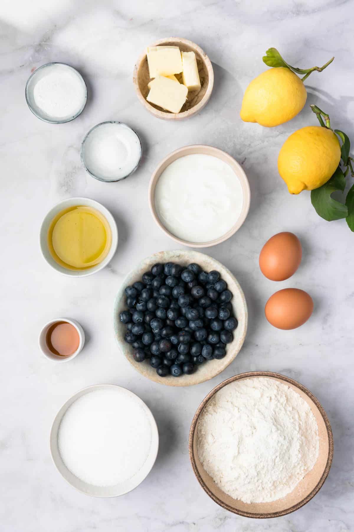 overhead view of the ingredients for lemon blueberry muffins in individual bowls.
