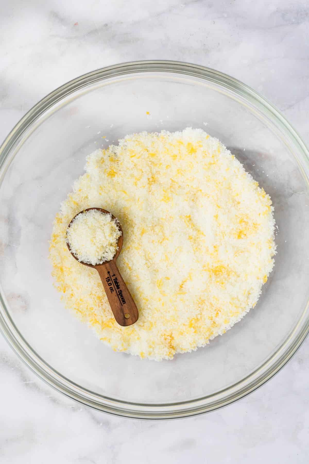 overhead view of lemon sugar for lemon blueberry muffins in a bowl.