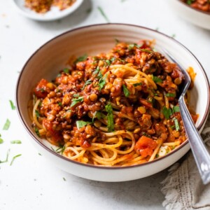 a bowl of pasta with lentils and red sauce