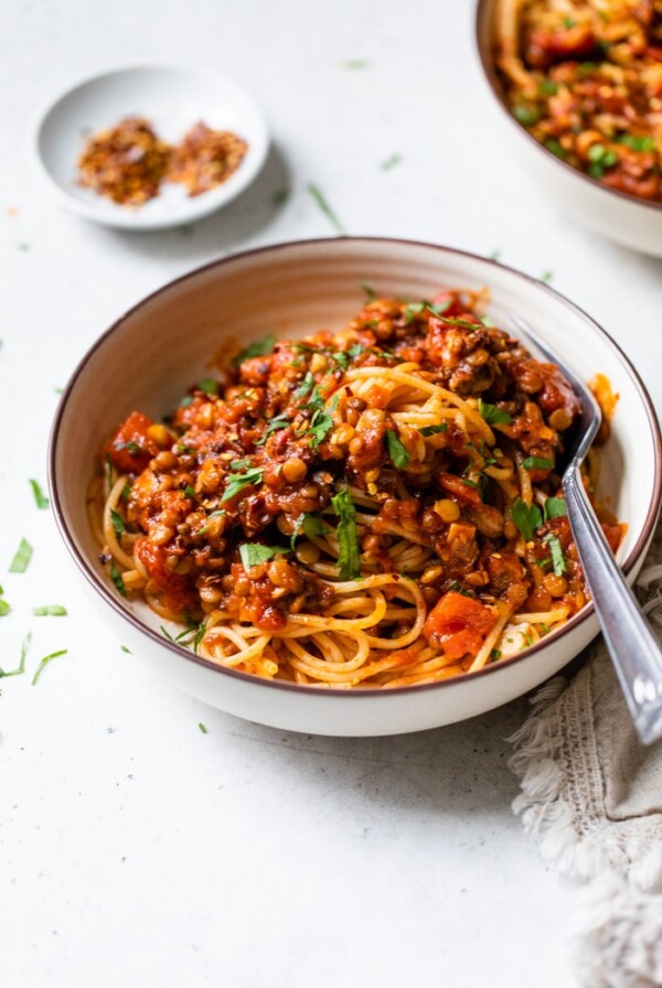 a bowl of pasta with lentils and red sauce
