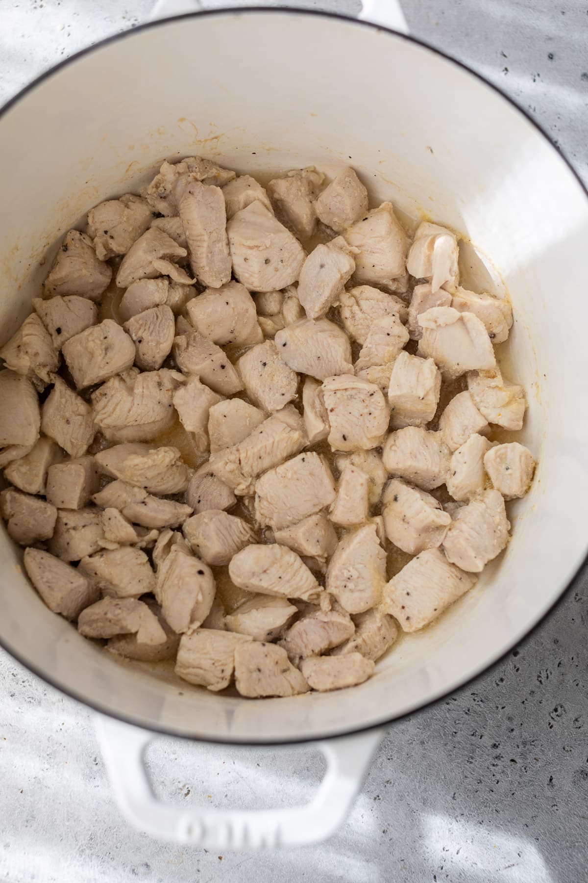 searing pieces of chicken breasts in a large pot.