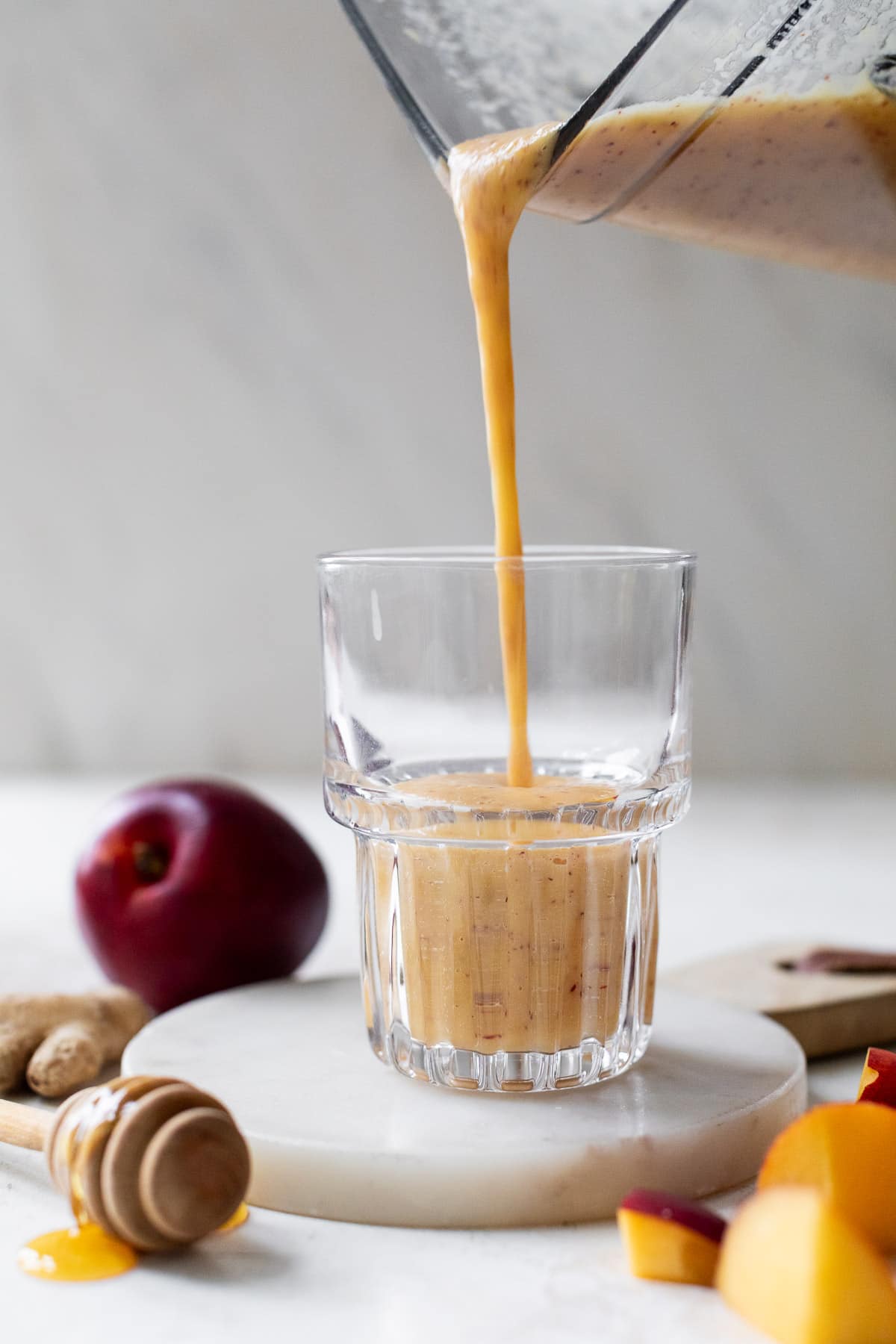 pouring a Nectarine Smoothie from a blender into a glass.