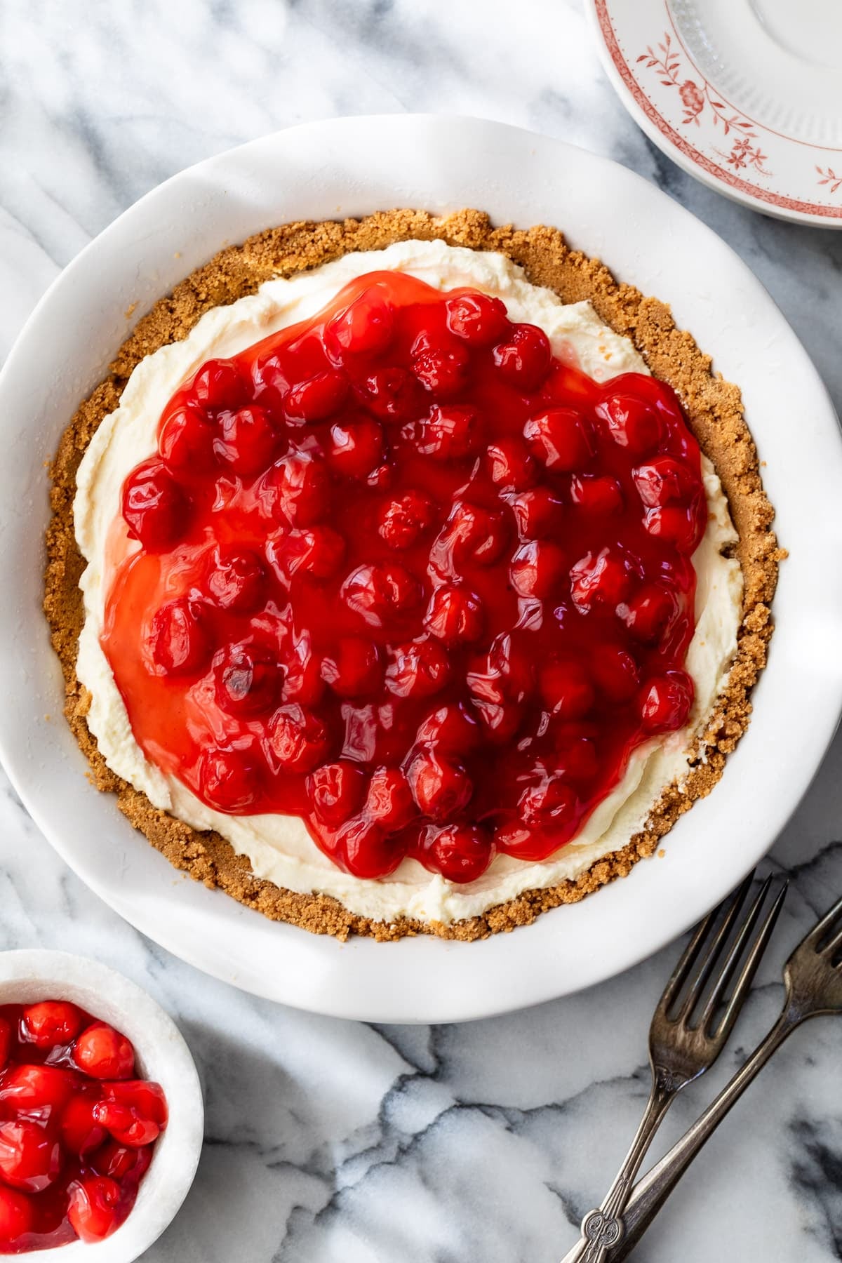 a whole pie in a pie pan topped with cherry pie filling