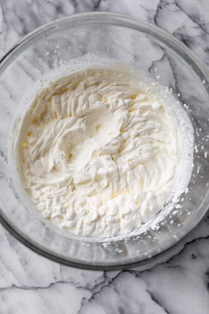 a large glass bowl filled with homemade whipped cream