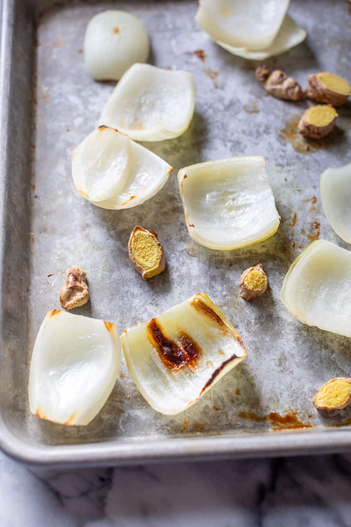 broiled onion and ginger slices on a baking sheet.
