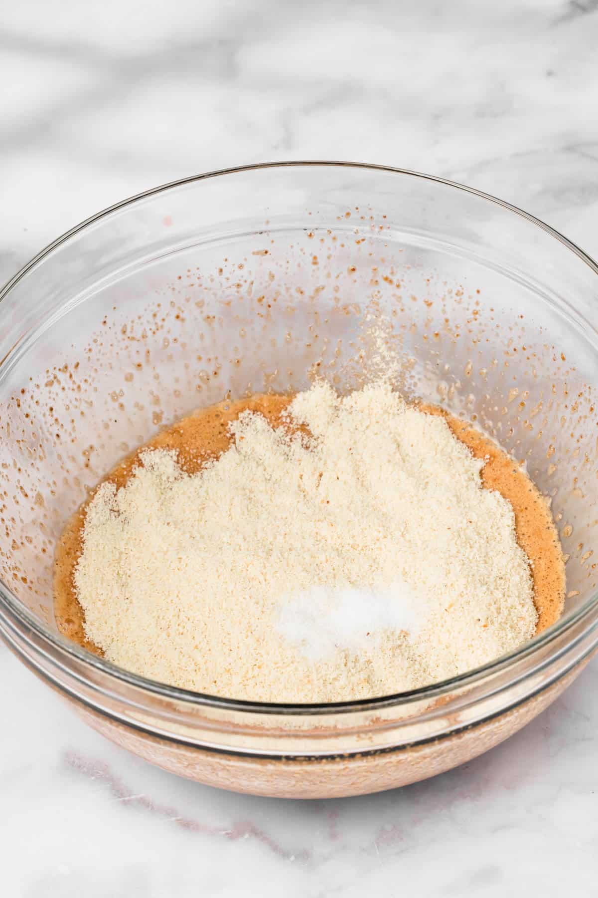 side view of the ingredients for paleo brownies in a glass bowl.