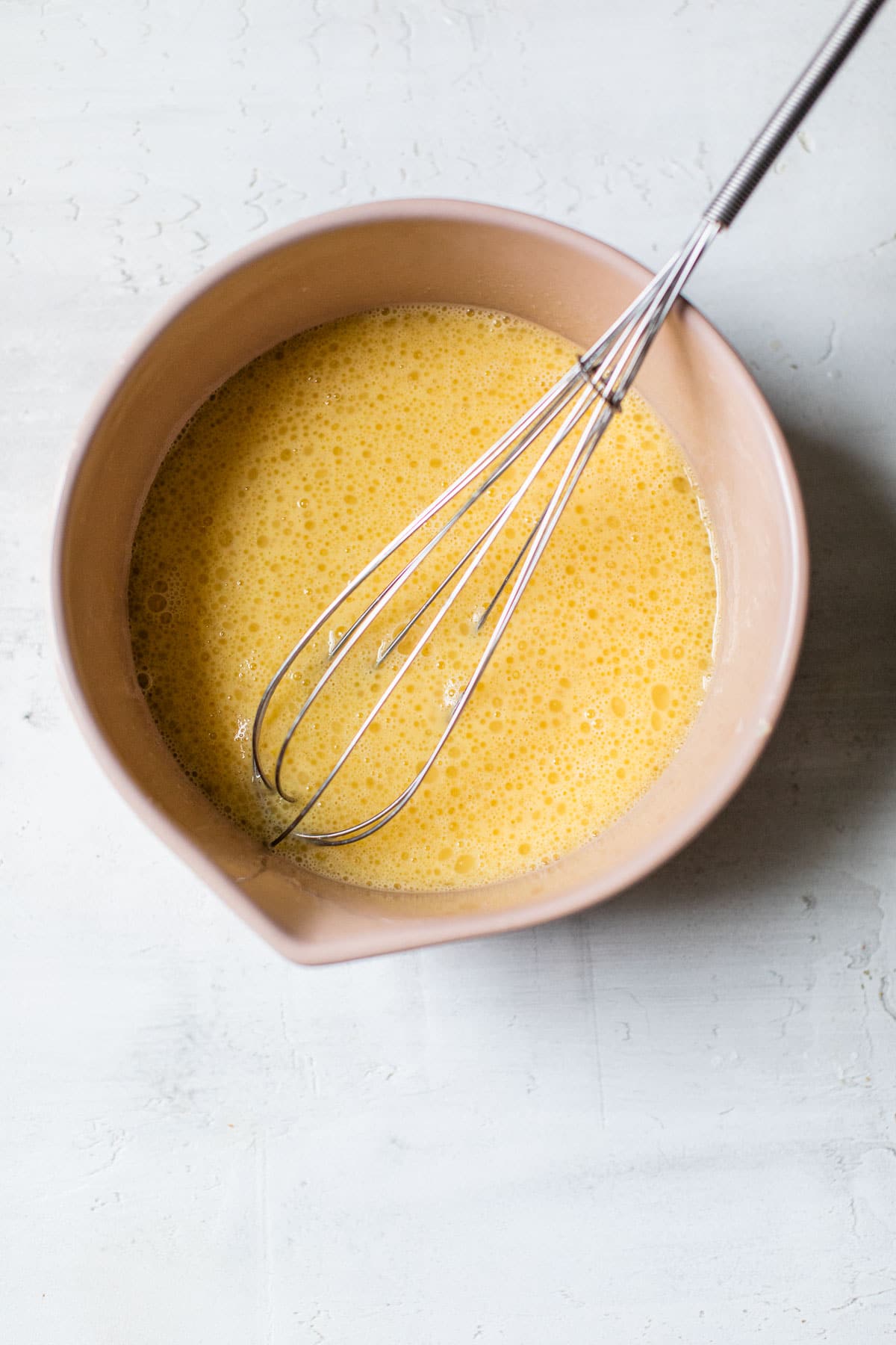 whisked eggs and coconut oil in a bowl