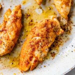 close up of a crispy chicken tender in a skillet