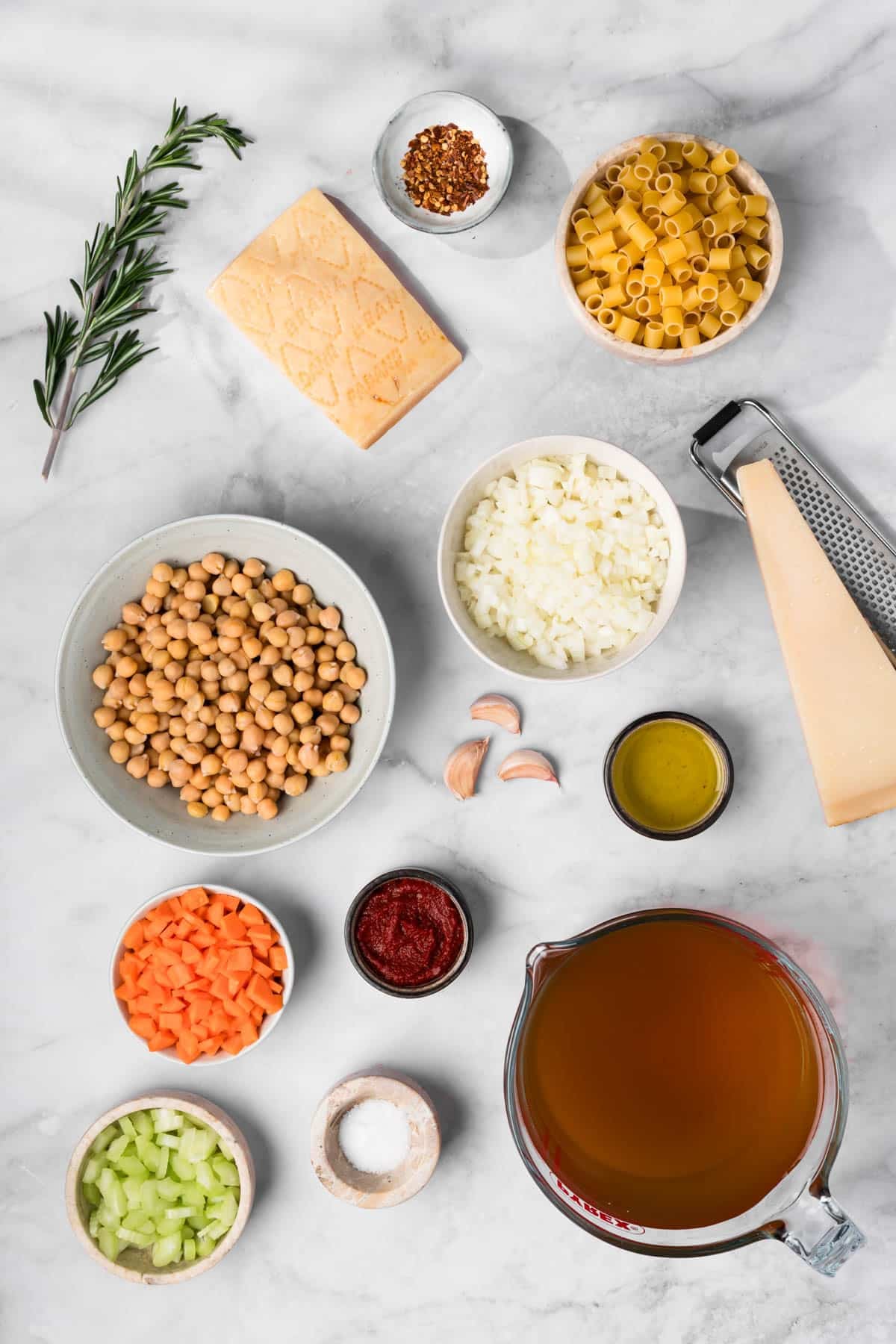 overhead view of the ingredients for pasta e ceci in individual bowls.