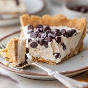 a slice of peanut butter cottage cheese pie on a plate with a bite cut off with a fork