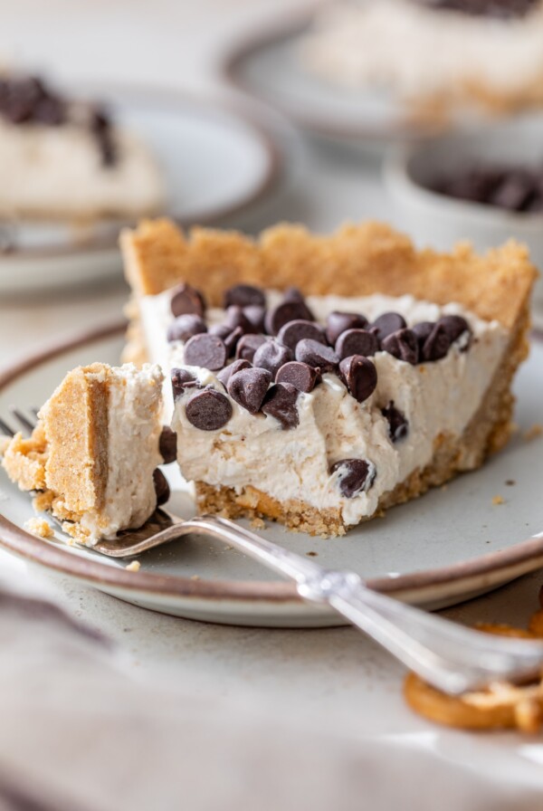 a slice of peanut butter cottage cheese pie on a plate with a bite cut off with a fork
