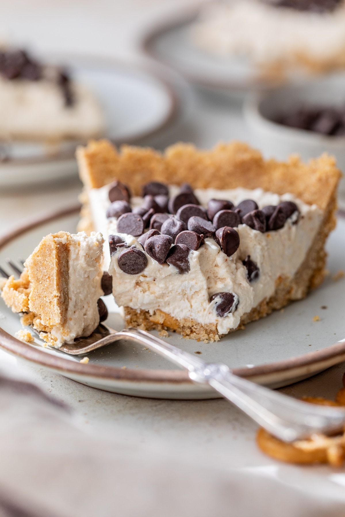 a slice of peanut butter cottage cheese pie on a plate with a bite cut off with a fork