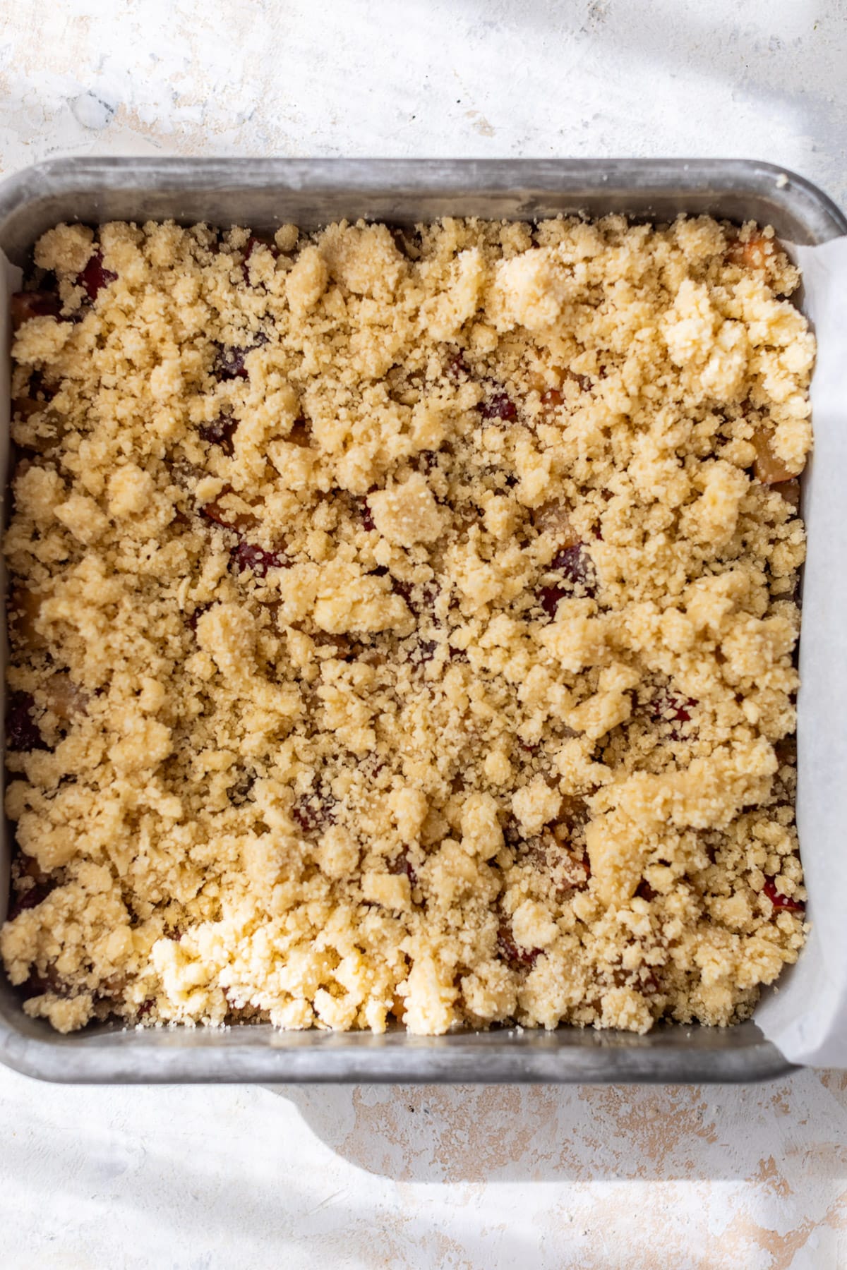 assembled and unbaked plum bars in a baking dish.