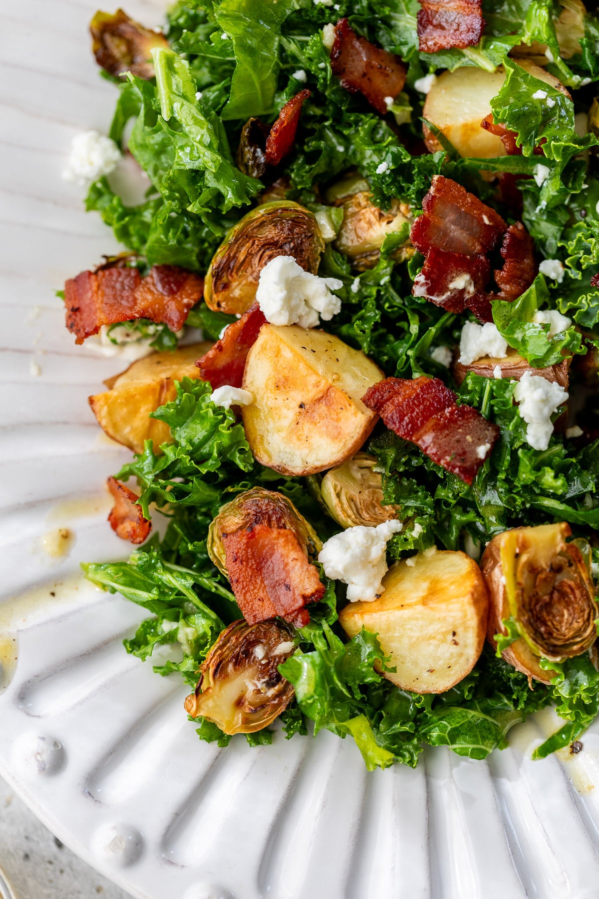 close up on a potato brussels sprouts salad on a large white platter.