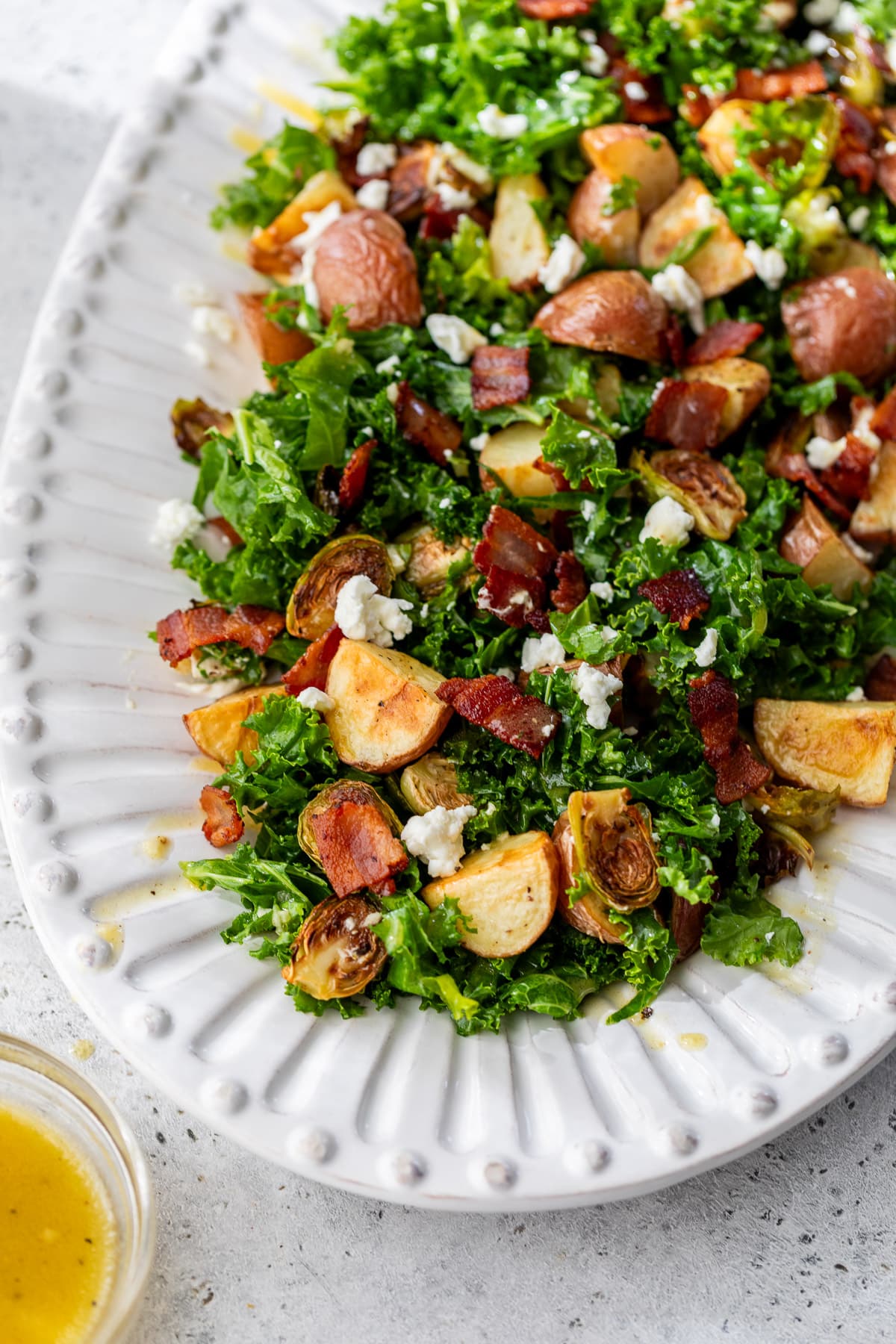 a potato brussels sprouts salad on a large white platter.