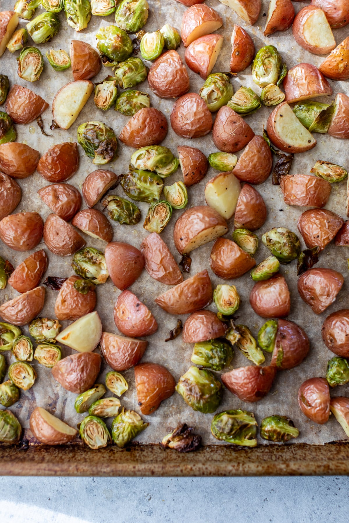 roasted red potatoes and brussels sprouts on a sheet pan.