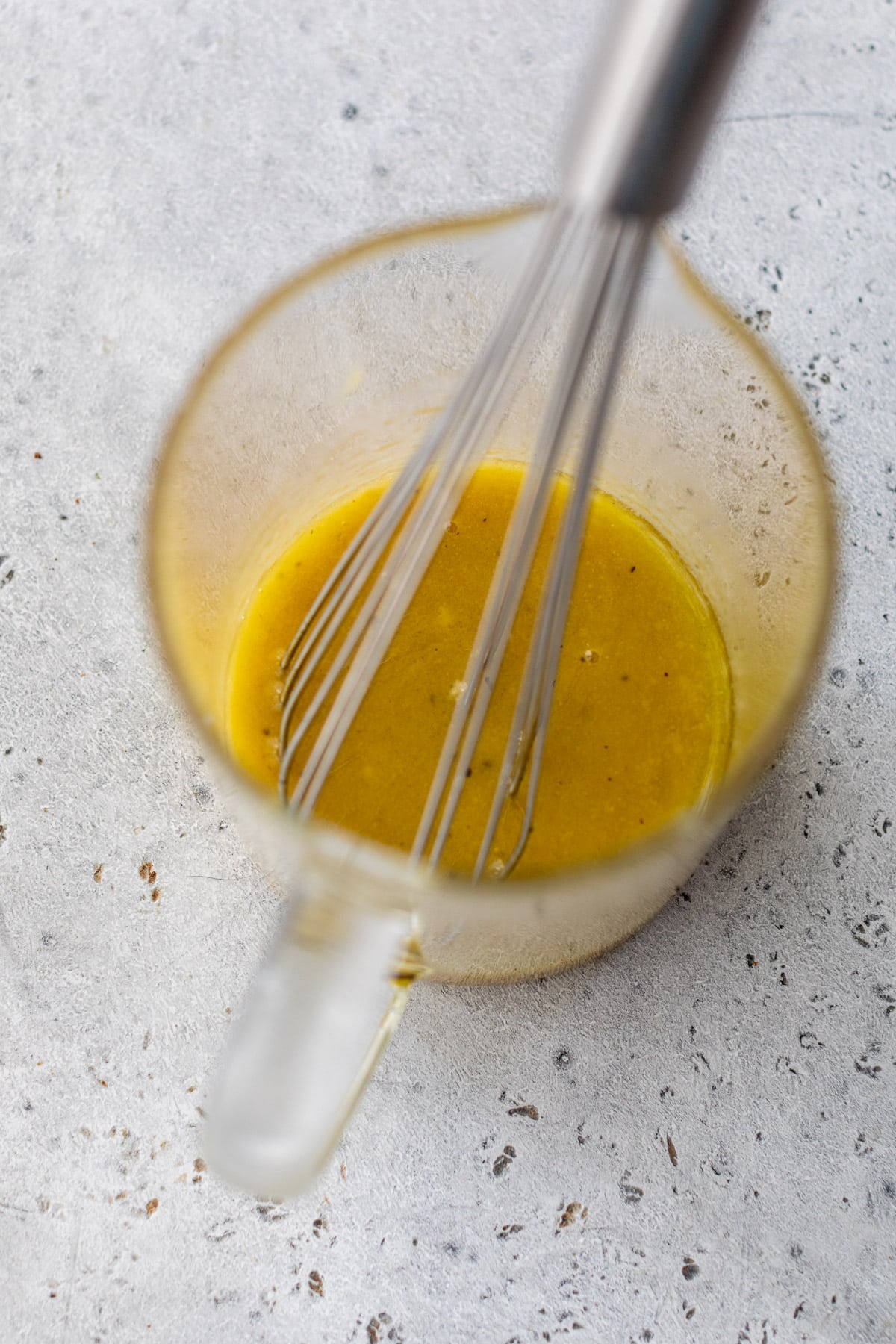 whisking a vinaigrette in a glass measuring cup.