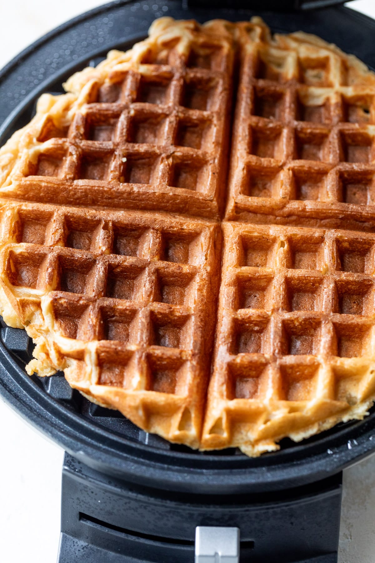 a protein waffle cooking on a waffle iron.