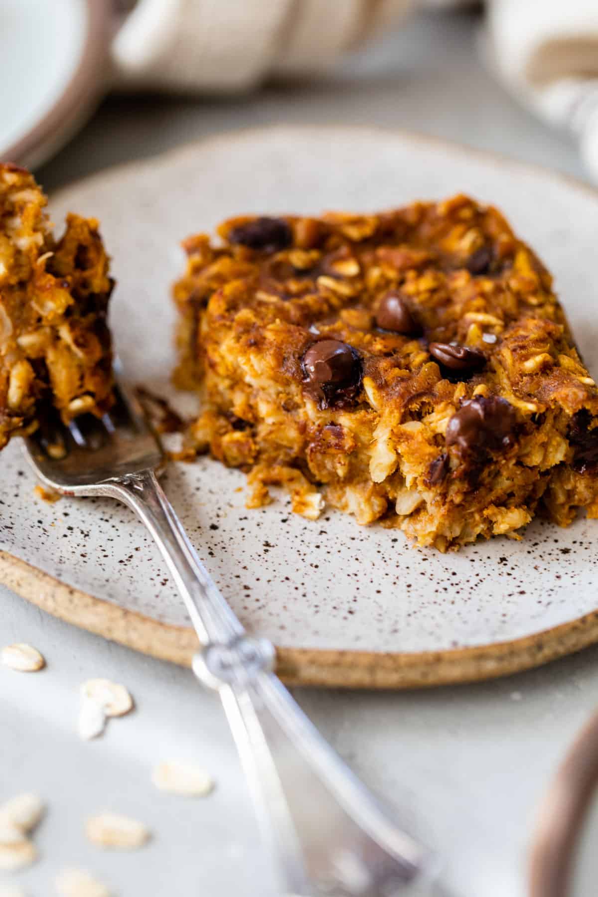 baked pumpkin oatmeal on a plate with a bite taken out with a fork