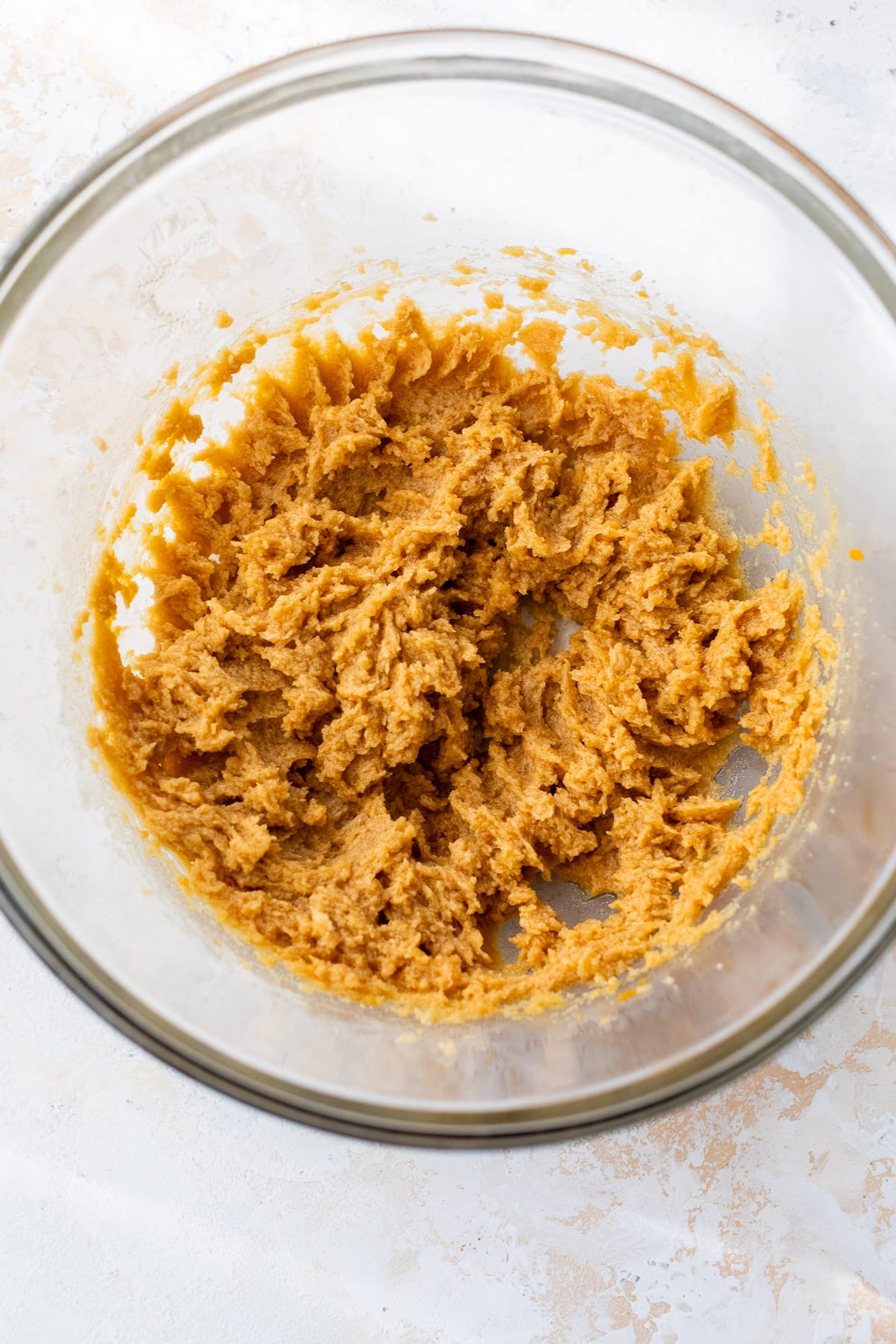 the wet mixed ingredients for Pumpkin Chocolate Chip Cookies in a glass bowl.