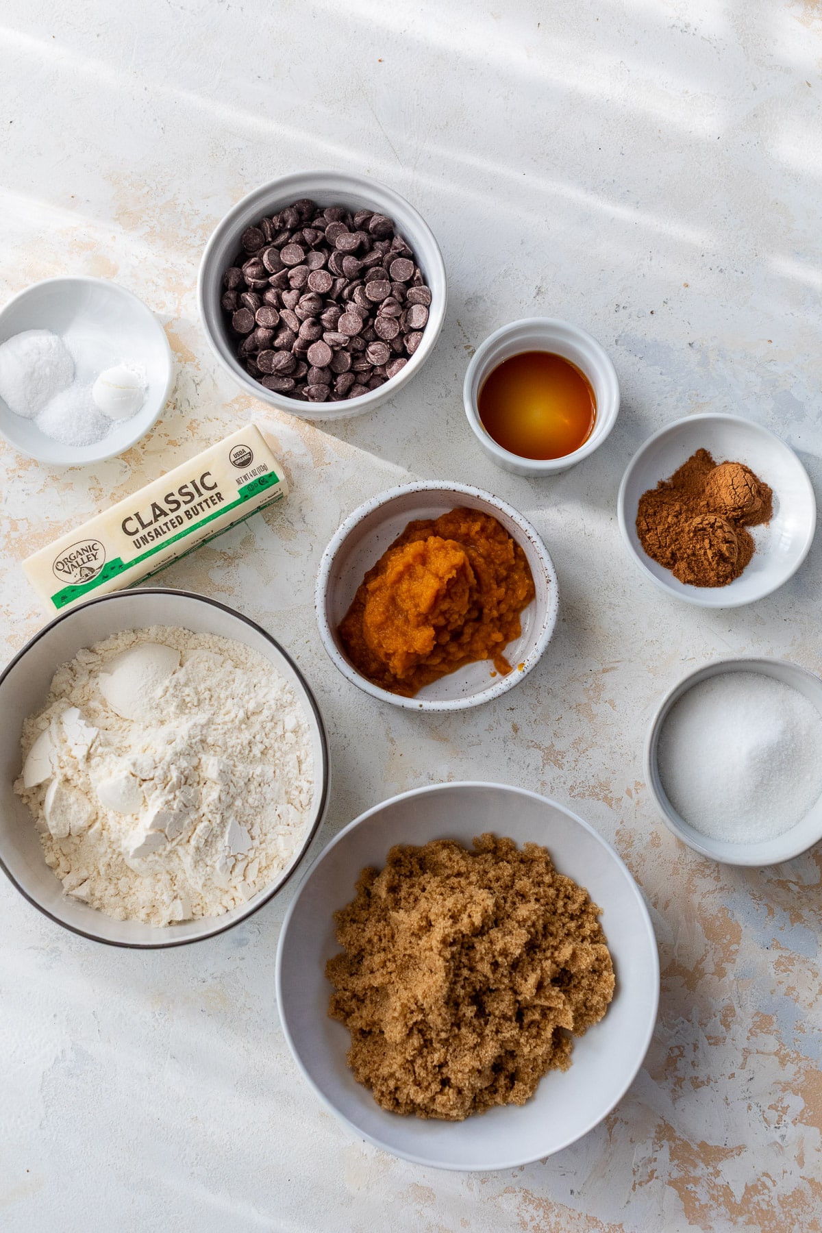 the ingredients for Pumpkin Chocolate Chip Cookies in individual white bowls.