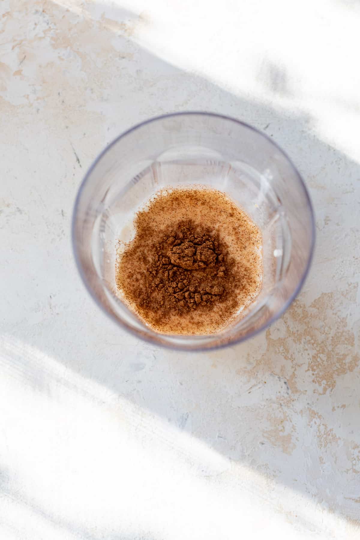 overhead view of ingredients for pumpkin creamer in a glass.