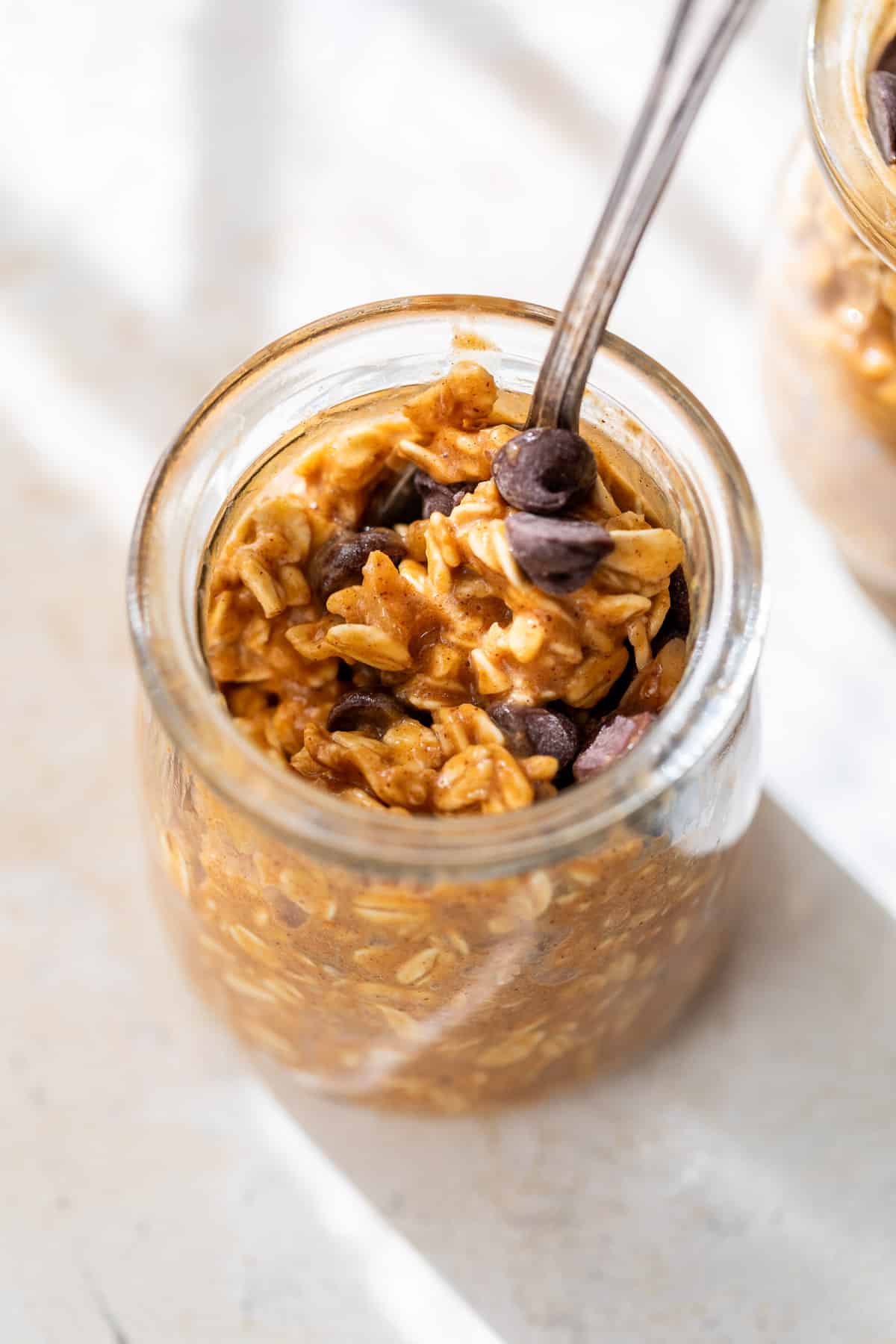 close up on pumpkin overnight oats in a glass jar.