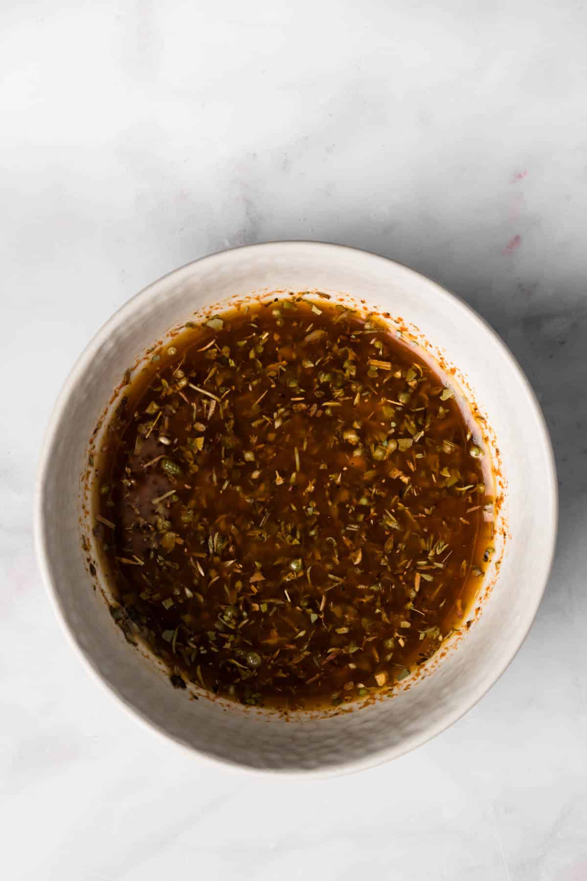 Overhead view of the marinade for sheet pan chicken and potatoes in a small bowl.