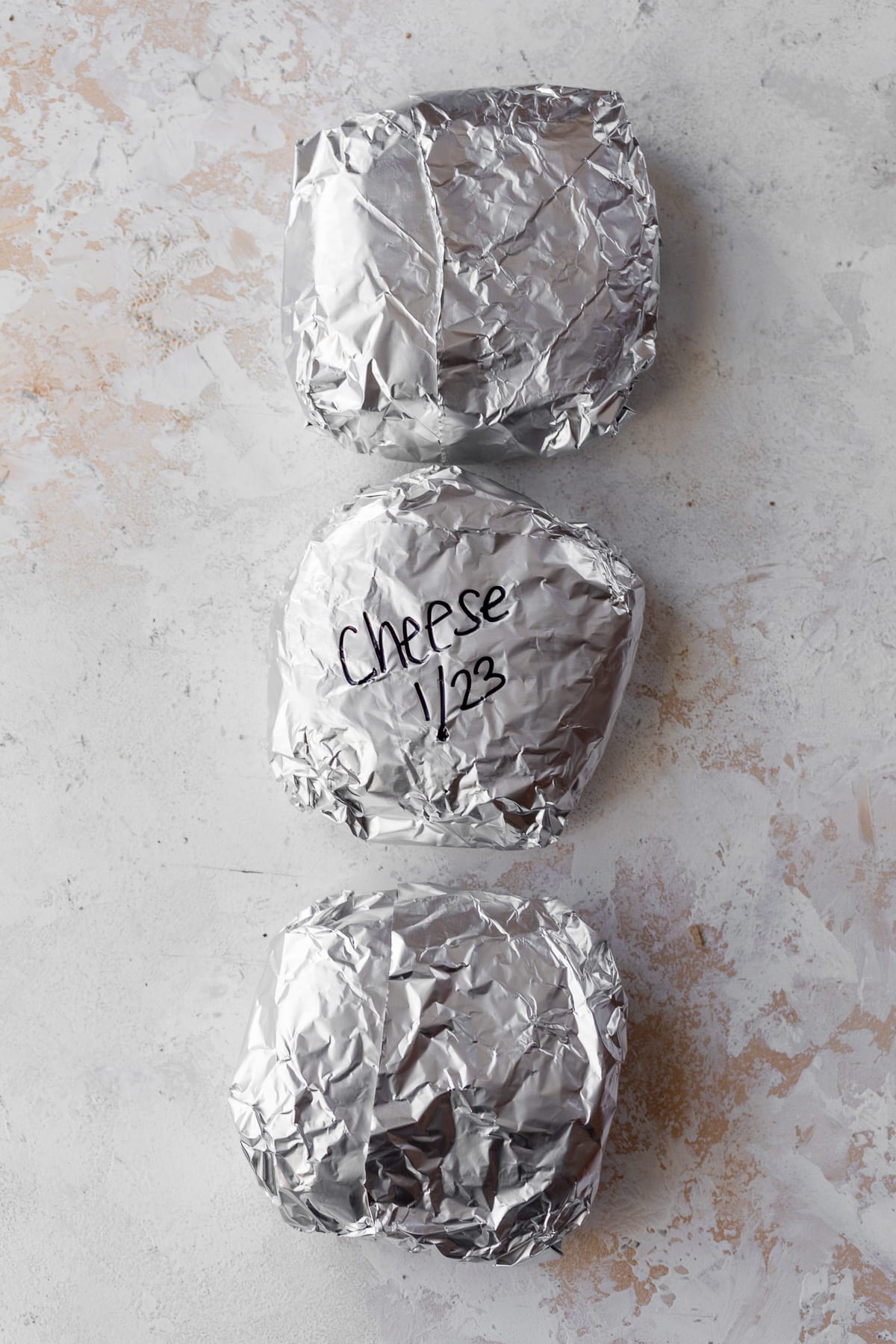 three breakfast sandwiches wrapped in foil