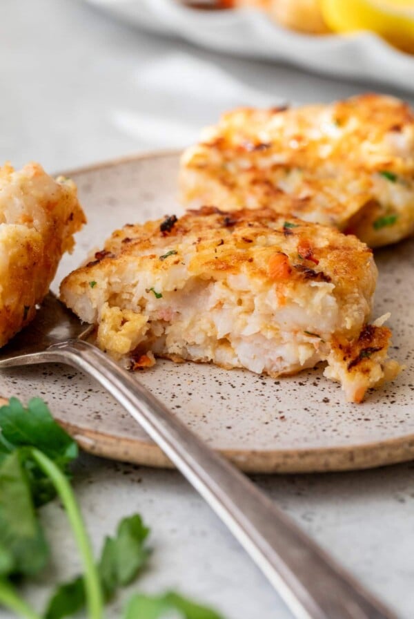 shrimp cake on a plate with a fork and a bite taken out