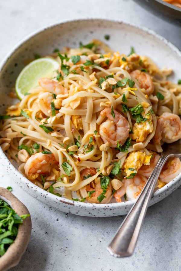 shrimp pad thai in a bowl with a fork