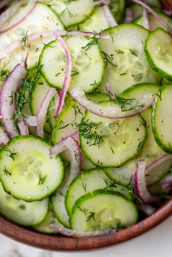 close up on a simple cucumber salad in a wood bowl.