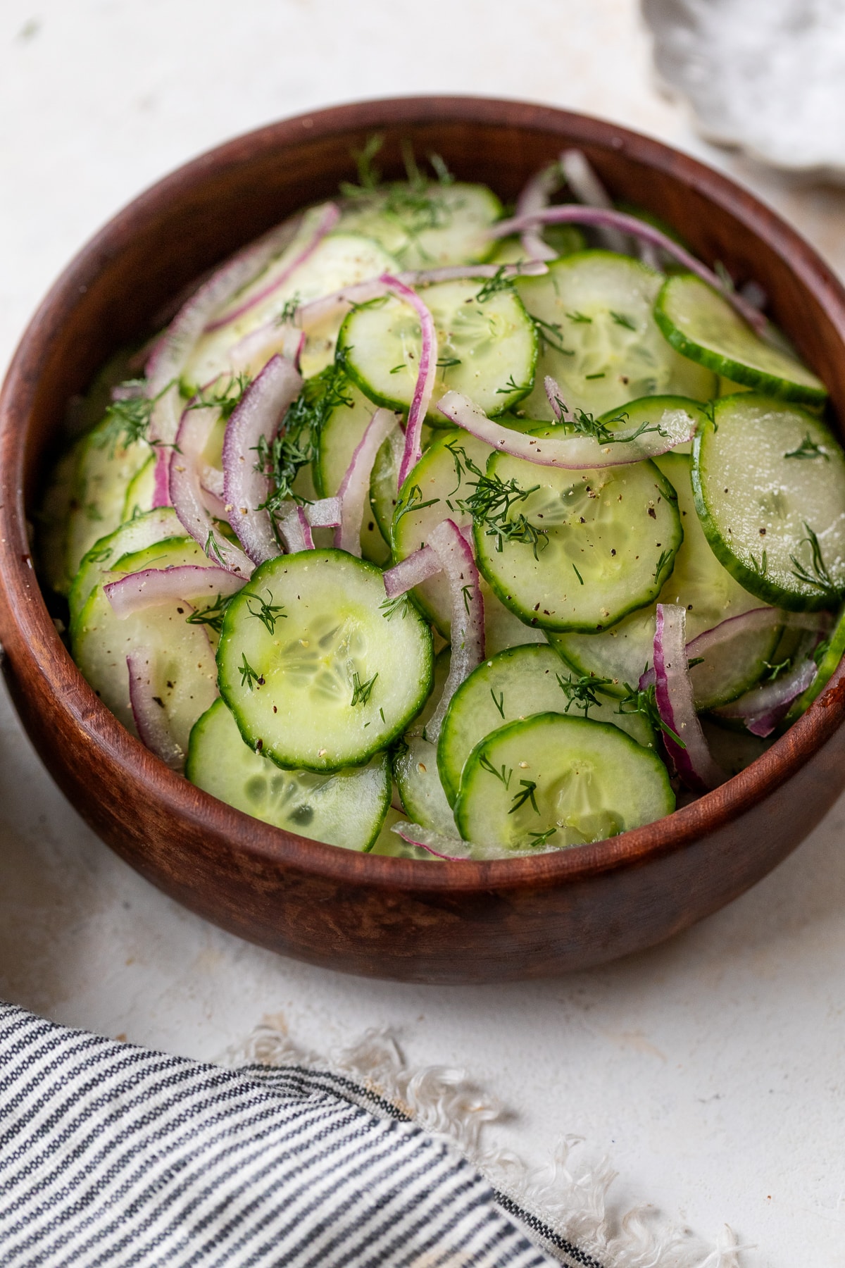 a simple cucumber salad in a wood bowl.