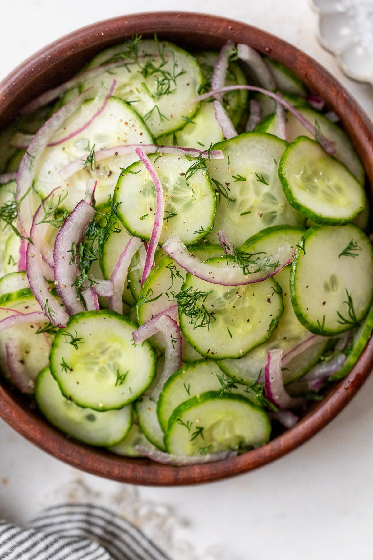 a simple cucumber salad in a wood bowl.