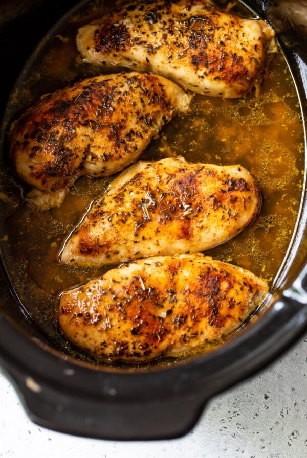 chicken breasts cooking in a slow cooker.