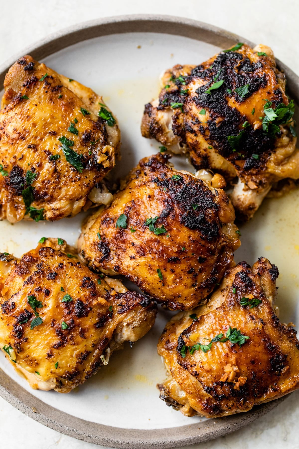 five cooked chicken thighs on a plate