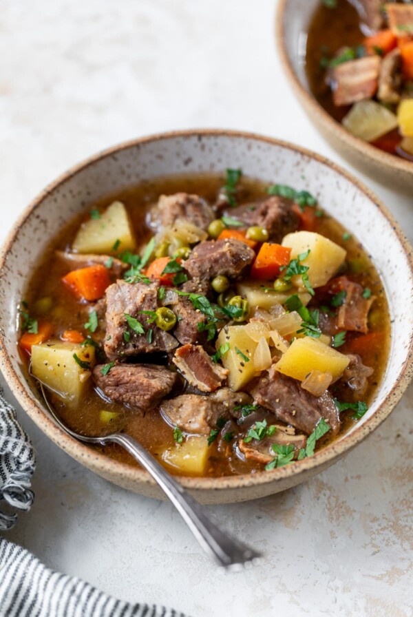 slow cooker lamb stew in a bowl with a spoon