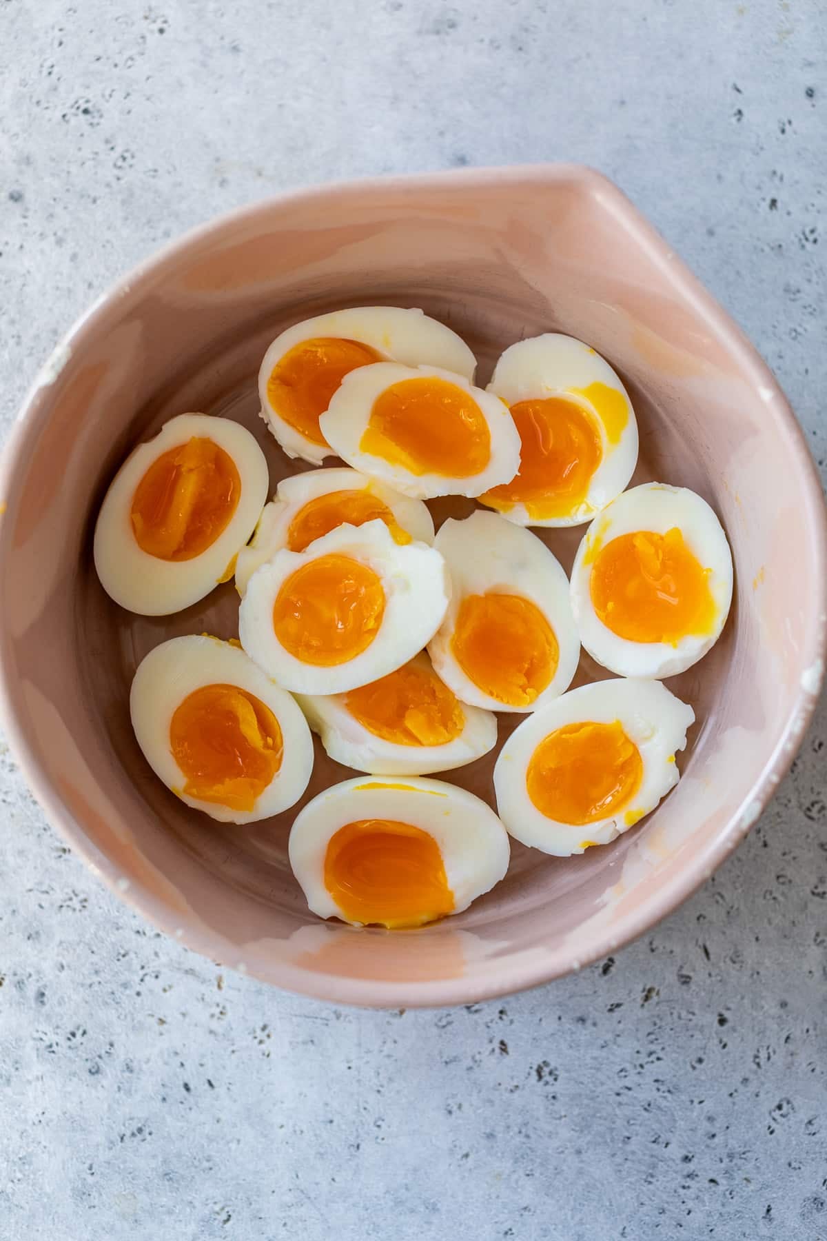 soft boiled eggs sliced in half and placed in a bowl