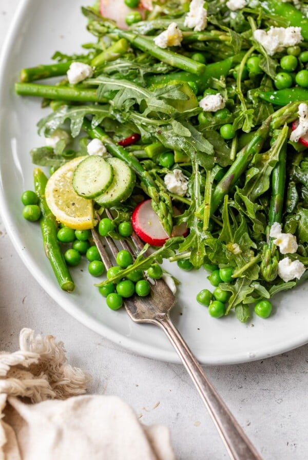 spring pea salad on a serving platter with a fork