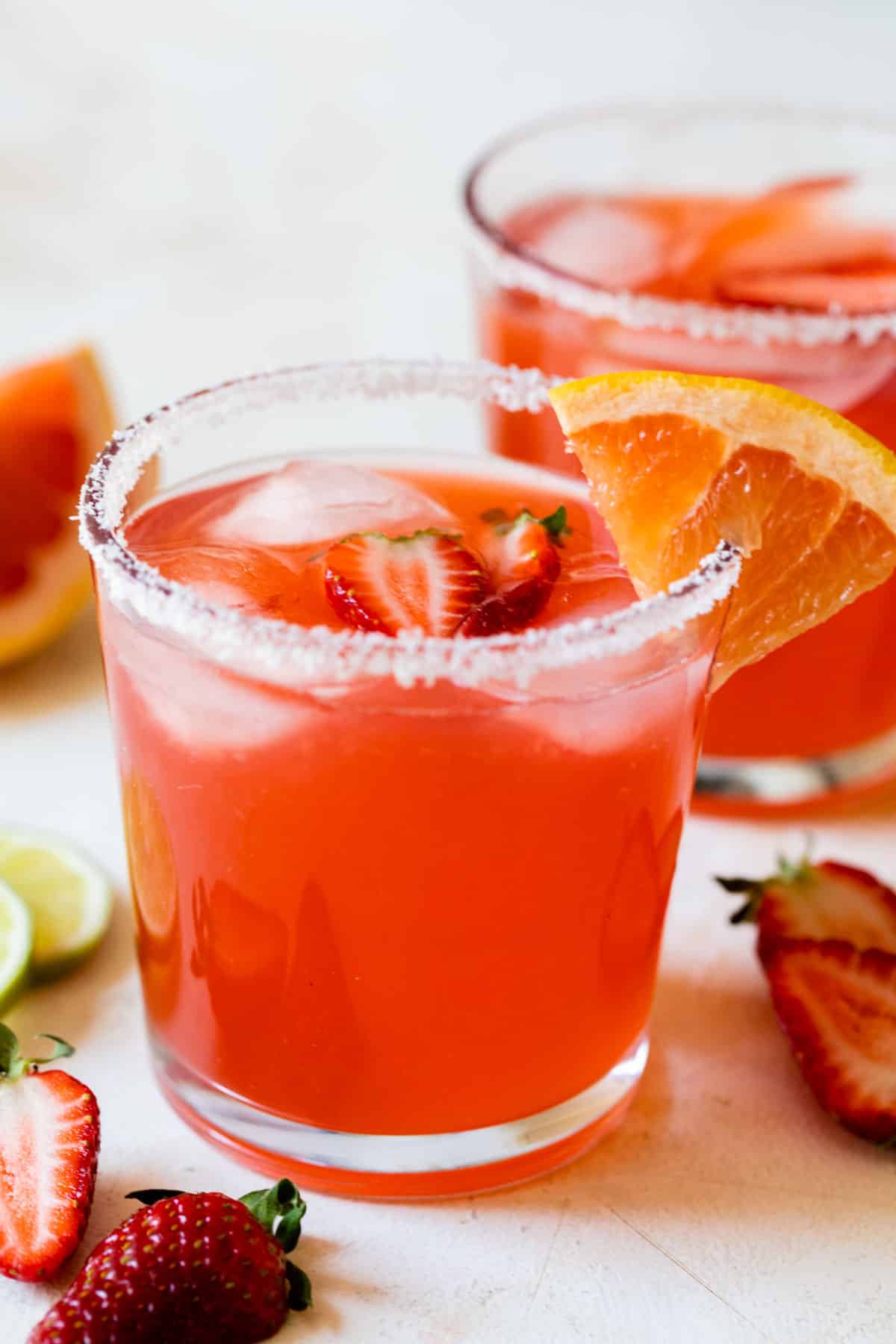 a side view of a strawberry ginger paloma in a sugar lined glass with a strawberry inside