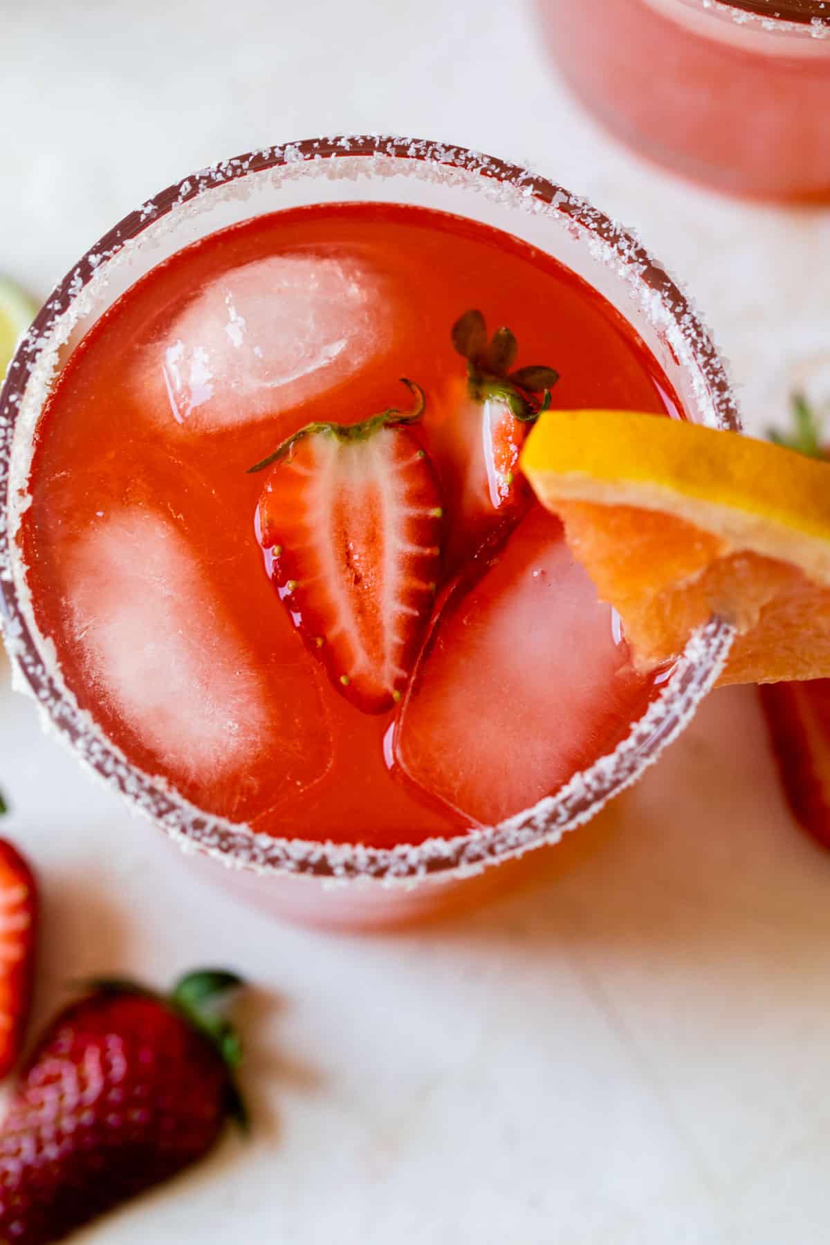 an overview of a strawberry ginger paloma in a sugar lined glass with a strawberry inside