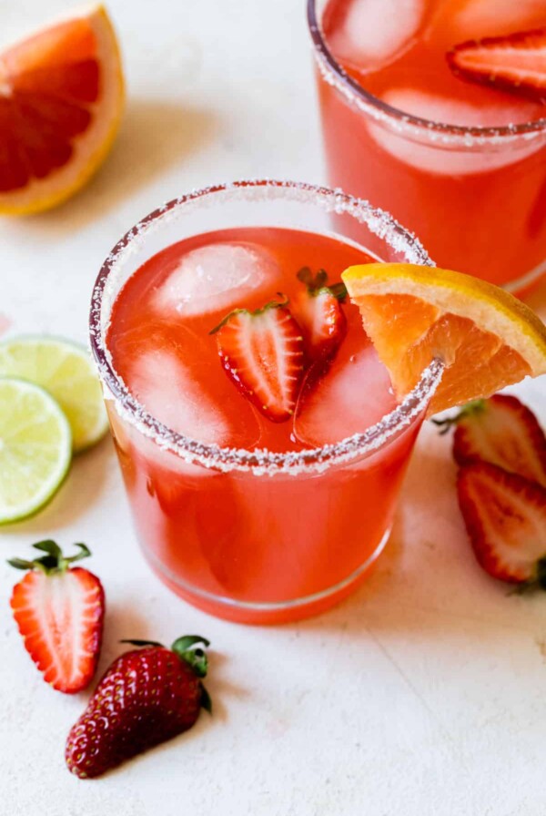 a strawberry ginger paloma in a sugar lined glass with a strawberry inside