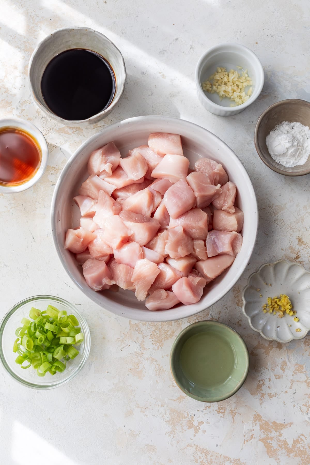 ingredients for teriyaki chicken in individual white bowls.