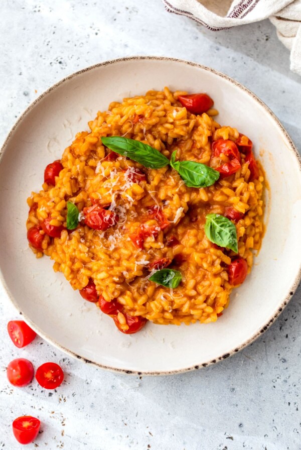 a bowl of risotto with tomatoes and fresh basil