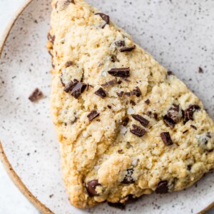 a scone on a plate topped with chopped chocolate