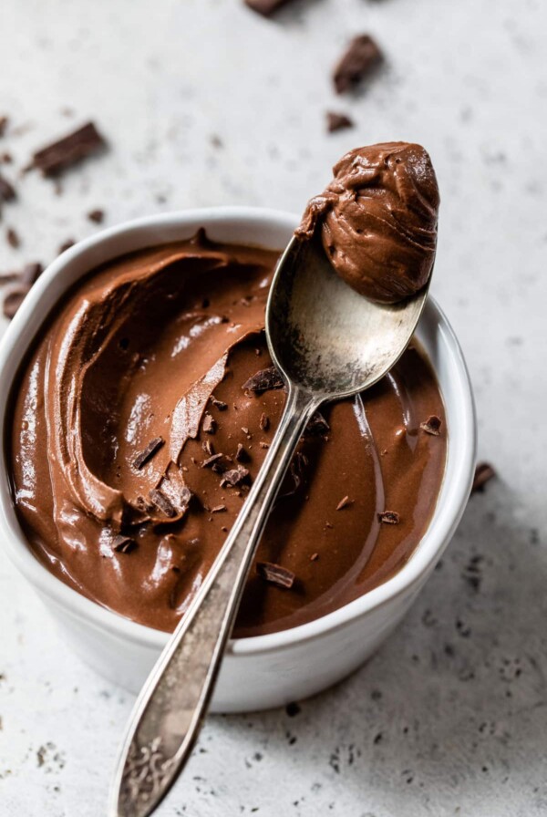 a spoonful of mousse sitting on top of a small bowl of chocolate mousse