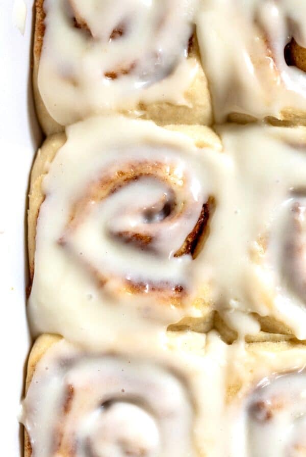close up on a cream cheese frosting-topped vegan cinnamon roll.