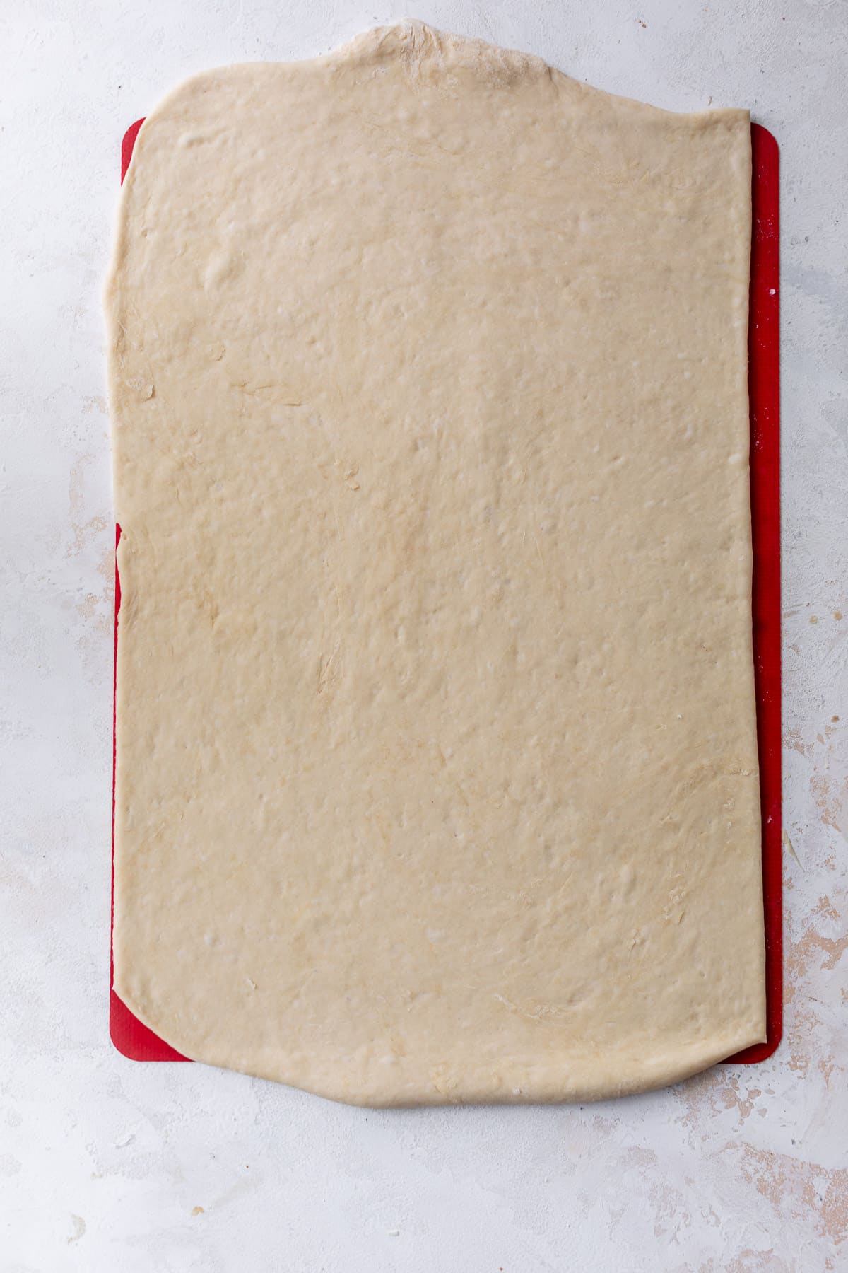 overhead view of vegan cinnamon roll dough rolled out into a rectangle.