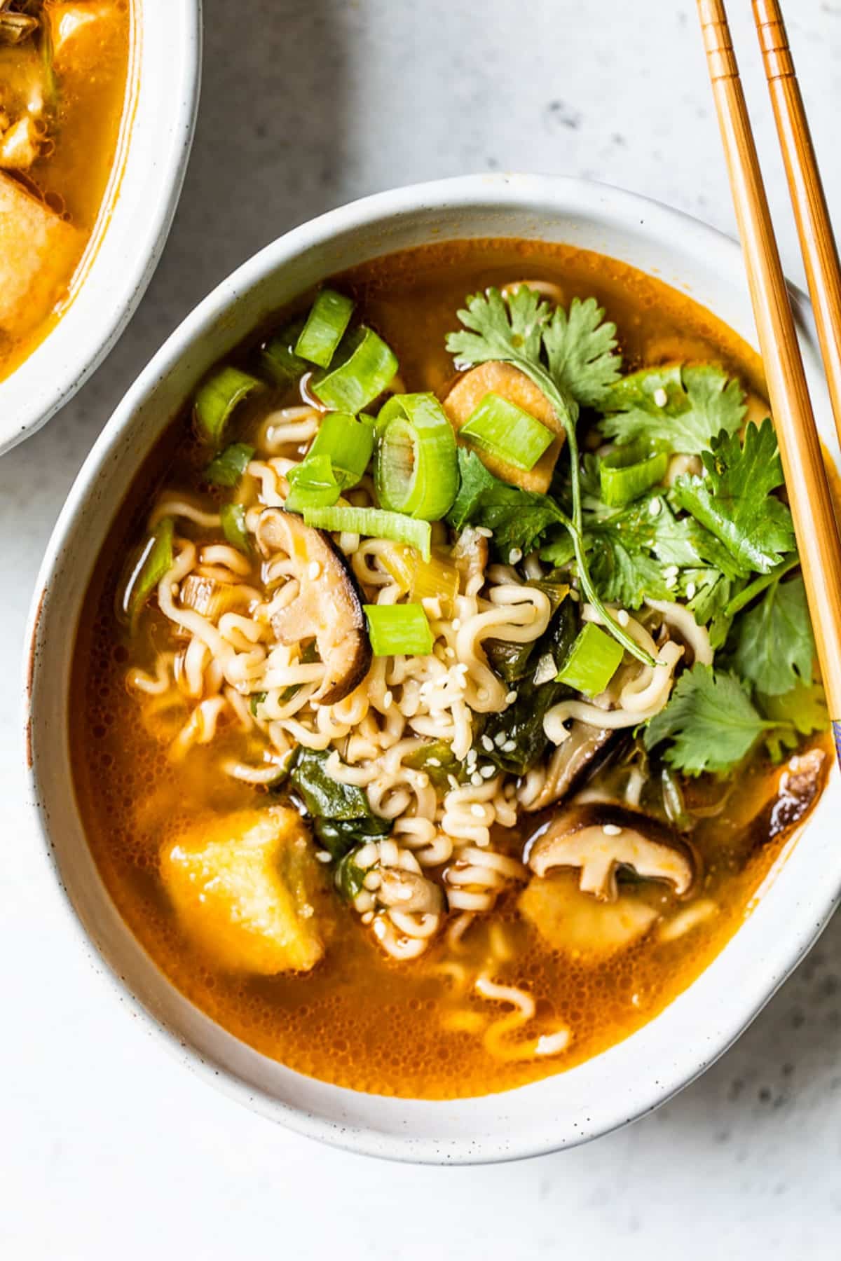 overhead view of a bowl of vegan ramen with chopsticks on top.